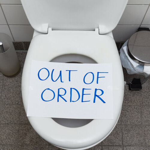 toilet with an out of order sign