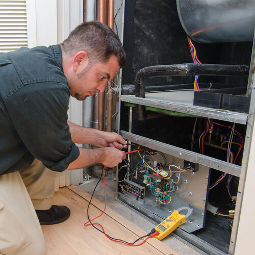 A Technician Repairs a Furnace.