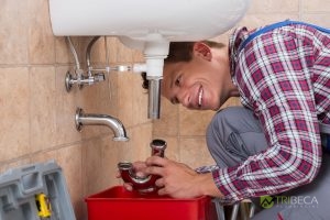 Man Working on Drain Pipe Under Sink