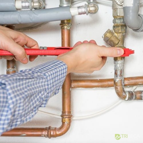 Plumber Hands With Tools Tightening Pipe Connections